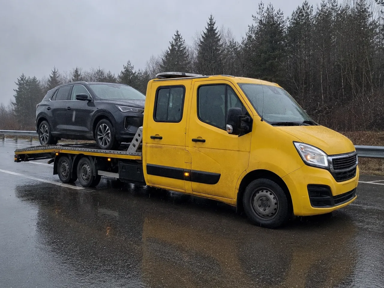 Holowanie srebrnego SUV-a na lawecie w deszczu – Krosno